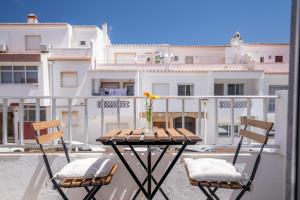 a table and chairs on a balcony with a building at Alto Mar Inn in Lagos