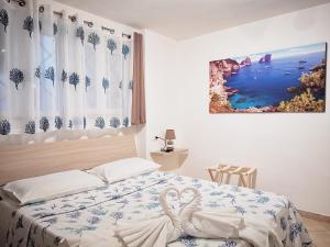 una camera da letto con un letto con due cigni sopra di B&B La margherita a Castellammare di Stabia
