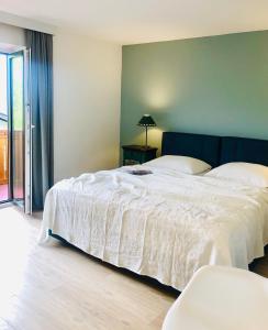 um quarto com uma cama grande e um edredão branco em Hotel Sonnenhof - bed & breakfast & appartements em Innsbruck
