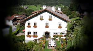una grande casa bianca con fioriere sopra di Apartments HAUS SCHÖN - Preise inclusive Pitztal Sommer Card a Jerzens