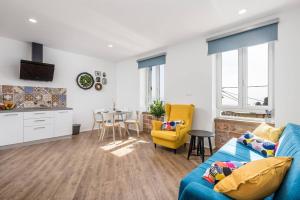 a living room with a blue couch and a kitchen at Apartment Villa Elena in Opatija