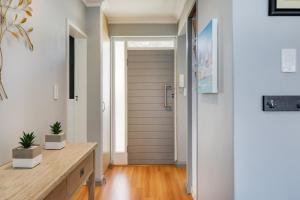 a hallway with a door and a wooden floor at Backup-Powered Bantry Bay View 2 Bed Apartment in Cape Town