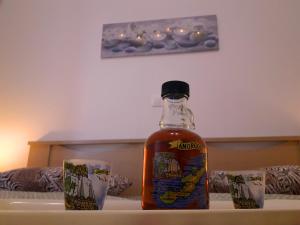 a bottle of alcohol sitting on a table next to a glass at Larinaki's Studios No3 in Amorgos