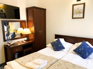 a hotel room with two beds and a mirror at Hotel Patria Zakopane Centrum in Zakopane