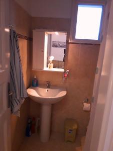 a small bathroom with a sink and a window at Larinaki's Studios No3 in Amorgos