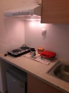 a kitchen counter with a stove and a sink at Larinaki's Studios No3 in Amorgos