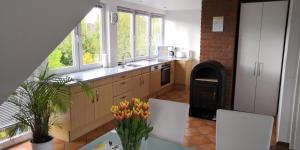 a kitchen with two white chairs and a table with flowers at Haus Lackner in Timmendorfer Strand