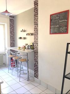 a kitchen with a bar with stools and a chalkboard at L'Appart Bleu - Lumineux F3 Mulhouse Gare/Centre in Mulhouse