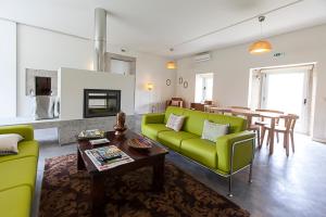 a living room with a green couch and a table at Casa dos Edras in Miranda do Douro