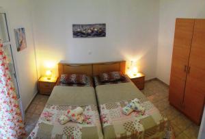 a small bedroom with two beds and two lamps at Larinaki's Studios No3 in Amorgos