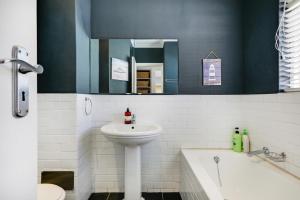 a bathroom with a sink and a toilet and a tub at Backup-Powered Bantry Bay View 2 Bed Apartment in Cape Town