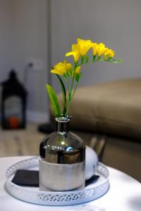 a vase with yellow flowers in it on a table at The Olive Green House in Burgas City