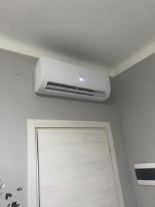 eine an der Decke montierte Klimaanlage an einer Wand über einer Tür in der Unterkunft Ylli home Sanremo in Sanremo