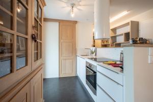 een keuken met witte werkbladen en houten kasten bij Saint Germain in Colmar