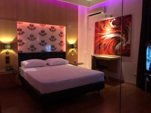 sypialnia z łóżkiem z fioletowym oświetleniem w obiekcie Olympic Hotel w Pireusie