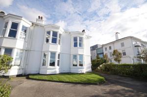 une maison blanche avec une pelouse devant elle dans l'établissement Grade 2 Listed Apartment, Southport Promenade, à Southport