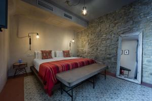 a bedroom with a bed and a dresser at The Riad - Adults Only in Tarifa