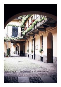 eine leere Straße mit einem Gebäude mit Pflanzen darauf in der Unterkunft Taking a WALK in the beating HEART of NAVIGLI in Mailand