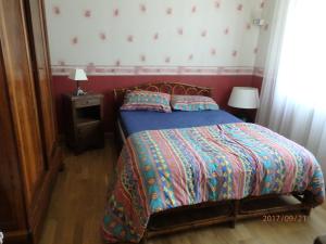 Un dormitorio con una cama con un edredón y almohadas de colores. en LA CHENOPE, en Souesmes