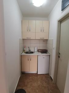 a small kitchen with white cabinets and a sink at Radović Apartments in Budva