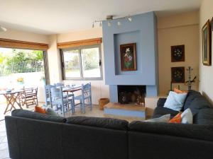 a living room with a couch and a fireplace at Beautiful house by the sea,Loutraki Skaloma. in Loutraki