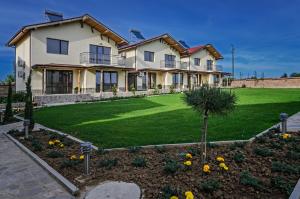 a large house with a green lawn in front of it at Alex Village in Shkorpilovtsi