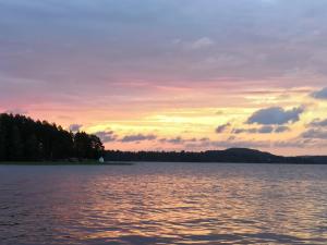 a sunset over a large body of water at Halkolanniemi in Muurame