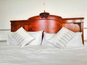 1 cama con almohadas blancas y cabecero de madera en La Casa dei Panorami di Colobraro, en Colobraro