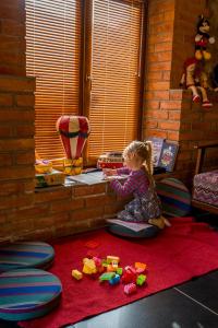 Una bambina seduta sul pavimento in una stanza di Rivendell a Borjomi