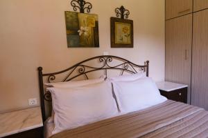 a bedroom with a bed with white pillows at Villa Ergina in Agios Nikolaos