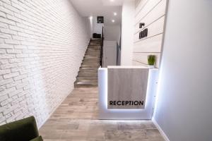 a staircase with a white brick wall and a reception counter at Is’land Hostel in Uzhhorod