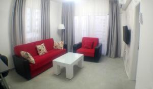 a living room with a red couch and two chairs at Angel's Apartment at Caesar Resort in Trikomo