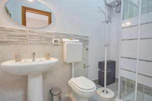 bagno con servizi igienici, lavandino e specchio di Sturzo 44 a Palermo