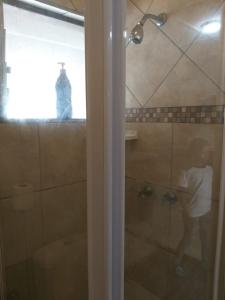 un hombre parado en una ducha en un baño en Unit 19 Villa Mia Apartment, en St Lucia