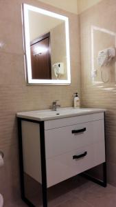 a bathroom with a sink and a mirror at PHILIPPOS Hotel Apartments in Nikiana