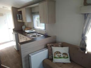 una pequeña cocina con sofá y fregadero en Borwick Lakes Haven en Burton