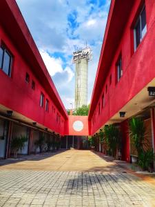 um edifício vermelho com uma torre de água ao fundo em Impulse Motel em São Bernardo do Campo
