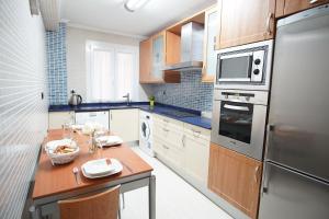 a kitchen with a wooden table and a refrigerator at Coqueto junto a Casco Viejo in Bilbao