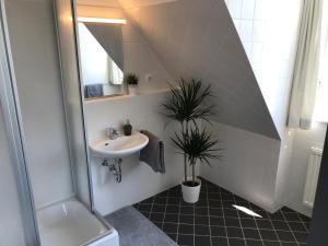 ein Bad mit einem Waschbecken und einem Spiegel in der Unterkunft Ferienwohnungen und Apartmenthaus Halle Saale - Villa Mathilda in Halle an der Saale