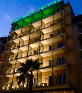 ピレウスにあるOlympic Hotelの横に緑の看板が立つ建物