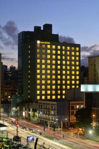 a lit up building in a city at night at Comfort Suítes Vitória in Vitória