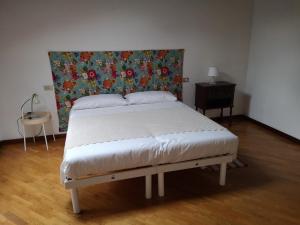 - une chambre dotée d'un lit avec une tête de lit fleurie dans l'établissement Camera con Vista, à Brescia