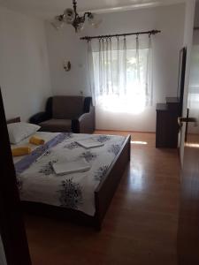 ein Schlafzimmer mit einem Bett, einem Sofa und einem Fenster in der Unterkunft Apartmani Čempres Senj in Senj