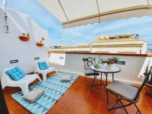 einen Balkon mit einem Tisch und Stühlen sowie ein Gebäude in der Unterkunft Una Terrazza per Due in Syrakus