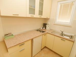 a kitchen with white cabinets and a sink at Apartments Villa Bondi in Makarska