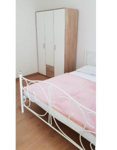 a bed with a white frame in a room at Studio apartman, 2+1 in Brodarica +16 photos