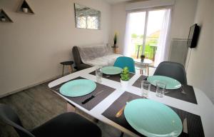 een eettafel met blauwe borden en stoelen bij Tout confort ! Climatisation, Calme, Piscine, Parking Gratuit, Terrasse, Wifi in Carcassonne