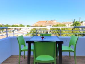 een tafel en stoelen op een balkon met uitzicht bij Tout confort ! Climatisation, Calme, Piscine, Parking Gratuit, Terrasse, Wifi in Carcassonne