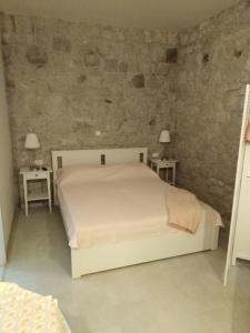 a bedroom with a white bed and two tables at Apartment Iris in Drasnice