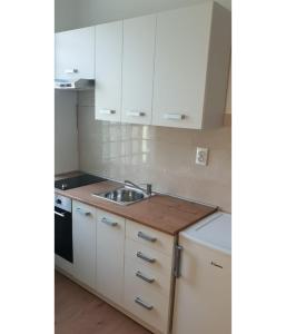 a kitchen with white cabinets and a sink at Studio apartman, 2+1 in Brodarica